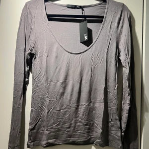 Grå långärmad tröja - Säljer en grå långärmad topp med djup rund halsringning från lager 157. Storlek Small. Aldrig använd, lappen är kvar. Köparen står för frakten 🩷