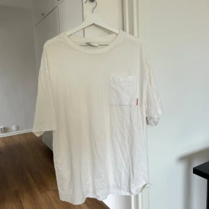 Acne T-shirt - Har en stor ficka vid bröstet med rosa Acne Studios logga