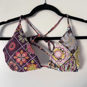 Färgglad bikiniöverdel med mönster - Snygg bikiniöverdel med ett färgglatt och detaljerat mönster. Den har knytband i nacken och ryggen för justerbar passform. Perfekt för en dag på stranden eller vid poolen! Storleken är L men passar mig bra som brukar ha S/M. Önskar du veta exakta mått? Tveka inte att höra av dig!