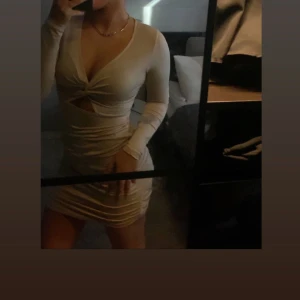 Beige klänning med knutdetalj - Snygg beige klänning med en knutdetalj framtill