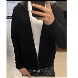 Svart zip up Massimo Dutti - Svart full zip up tröja från Massimo dutti i exemplarisk kvalitet och skick. Knappt använd, inga slitage alls. Gjord av extrafine cotton i storlek s. Hör av er vid andra frågor eller funderingar. 