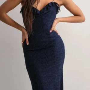 Mörkblå långklänning från Nelly  - Elegant mörkblå långklänning med en figurnära passform. Klänningen är i spets och är perfekt balen. Sålde slut på hemsidan jättefort. Stretchigt material! Prislappen är kvar!