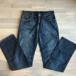 Mörkblå Nudie Jeans slim Jim  - Snygga mörkblå Nudie Jeans i modellen Slim Jim. De har en slim passform och är tillverkade med 98% bomull och 2% elastan. Topp kvalitet på jeansen då de inte är använda🤩 Storlek W32 L34.