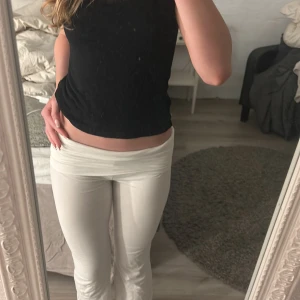 Vita byxor från Gina Tricot - Snygga vita byxor från Gina Tricot med en tight passform. Byxorna är lågmidjade och har en stilren design som passar perfekt för olika tillfällen. De är tillverkade i ett mjukt och bekvämt material.