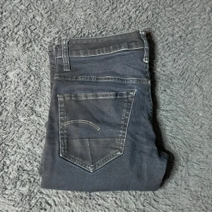 G-star jeans  - Snygga svarta g-star  jeansbyxor med klassisk femficksdesign och kontrastsömmar. De har en rak passform och är tillverkade i ett slitstarkt material. Perfekta för en stilren look.