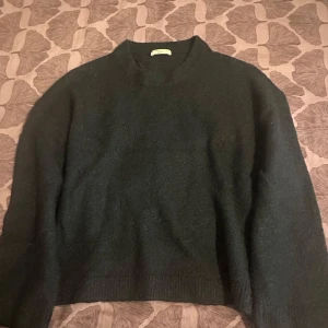 Svart stickad tröja från Gina Tricot - Mysig svart stickad tröja från Gina Tricot i storlek S. Tröjan har en klassisk rund halsringning och långa ärmar. Perfekt för lager-på-lager och passar till allt. Enkel och stilren design som funkar året om.