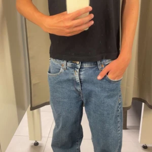 Blå jeans från Replay Regulars - Säljer ett par klassiska blå jeans från Replay Regulars med snyggt rakt snitt och gul kontrastsöm. Jeansen har fem fickor, normal passform och är tillverkade i slitstarkt denim. Perfekta för dig som gillar en tidlös och avslappnad look.