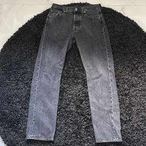 Levi's 501 grå jeans straight fit - Klassiska Levi's 501 jeans i snygg grå tvätt. Rak passform med normal midja och fem fickor. Jeansen är tillverkade i robust denim och har den ikoniska läderpatchen bak. Perfekta för en avslappnad och stilren look. Jag är 181 cm.