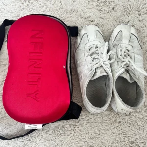 Vita cheerleading sneakers från Nfinity - Vita cheer-skor. Köpta för ca 1 300kr. Stl 8 / 39. Medföljer en röd och vit hård väska med Nfinity-logga. Skorna är lite smutsiga (syns på bilderna) men går nog bort om man skrubbar lite. Använda 1,5 säsong. 