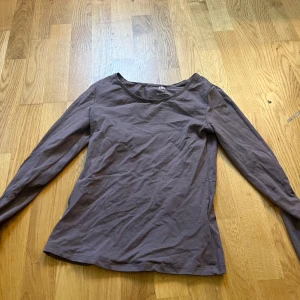 Brun långärmad tröja från 157 - En basic brun långärmad tröja från 157 i mjuk bomullsblandning med lite stretch. Tröjan har rund halsringning och en enkel, figurnära passform som funkar till allt. Perfekt att styla med jeans eller kjol för en chill look.