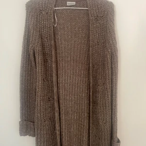 Beige stickad kofta från Lexington - Mysig lång beige stickad kofta från  med öppen front och diskret mönsterstickning. Perfekt att slänga på sig över en t-shirt eller topp. Ärmarna är långa och koftan har en avslappnad passform.