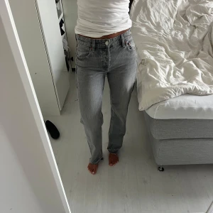Grå jeans  - Gråa jeans med slitningar längst ner. Tyvärr har de gått sönder lite vid hälen på ena benet. Sitter bra på mig som är 164