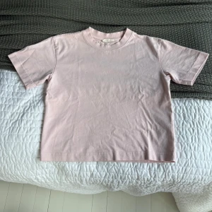 Ljusrosa basic t-shirt i bomull - Enkel och stilren ljusrosa t-shirt med korta ärmar och rund hals. Den är i mycket bra skick och jag säljer den pågrund av att den inte kommer till användning. Hör av er kring frågor, pris kan diskuteras💞