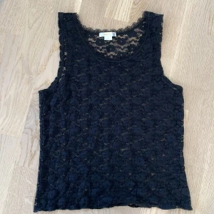 Super fint svart spetslinne från Gina Tricot💕 - Säljer ett svart spetslinne från Gina Tricot med blommigt mönster. Perfekt att styla lager på lager eller till ett par snygga jeans💞