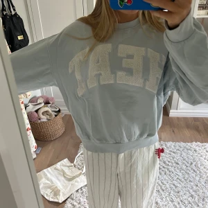 Ljusblå sweatshirt från Weekday - Supermjuk ljusblå sweatshirt från Weekday med stora vita bokstäver i teddy-tyg framtill. Oversized passform och rund hals. Perfekt för chill dagar och enkel att styla med jeans eller mjukisbyxor.💕