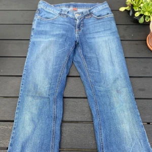 Blå bootcut jeans från Vila, M - Snygga blå jeans från Vila i modellen Pyramid Jeans. De har klassisk femficksdesign, kontrastsömmar och bootcut-ben. Jeansen är i mellanblå tvätt med lätt slitning och tillverkade i jeanstyg. Kontakta mig för ytterligare information samt pris diskution