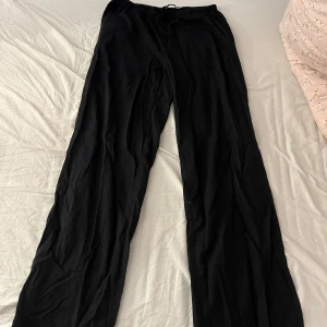 Svarta vida linnebyxor lager 157  - Svarta linnebyxor från lager 157 i storlek XS. Byxorna har en loose och wide passform med resår och snörning i midjan. Perfekta för chill dagar eller när du vill ha något bekvämt men ändå stilrent.