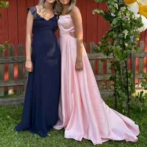 Rosa Balkläning🩷 - Säljer nu min älskade rosa Balkläning, Färgen heter pärlrosa och den blänker lite. Klänningen har ett ungefär 30-40cm långt släpp efter sig. Klänningen har knytning i ryggen med långa snören så går och ändra storlek i ryggen väldigt mycket. Den har en slits vid benet men inget som direkt syns. Jag är 174cm lång och klänningen är lite lång på mig. Klänningen är insyd vid midjan men de gå och sprätta upp och inget som förstör klänningen. Kontakta för fler bilder.🩷💖