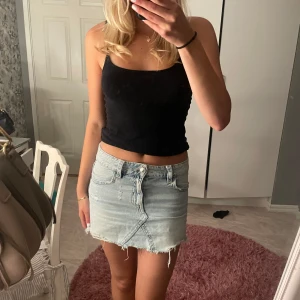 Ljusblå jeanskjol med rå kant - Säljer en ljusblå jeanskjol i kort modell med snygga slitningar och fickor. Storlek 164