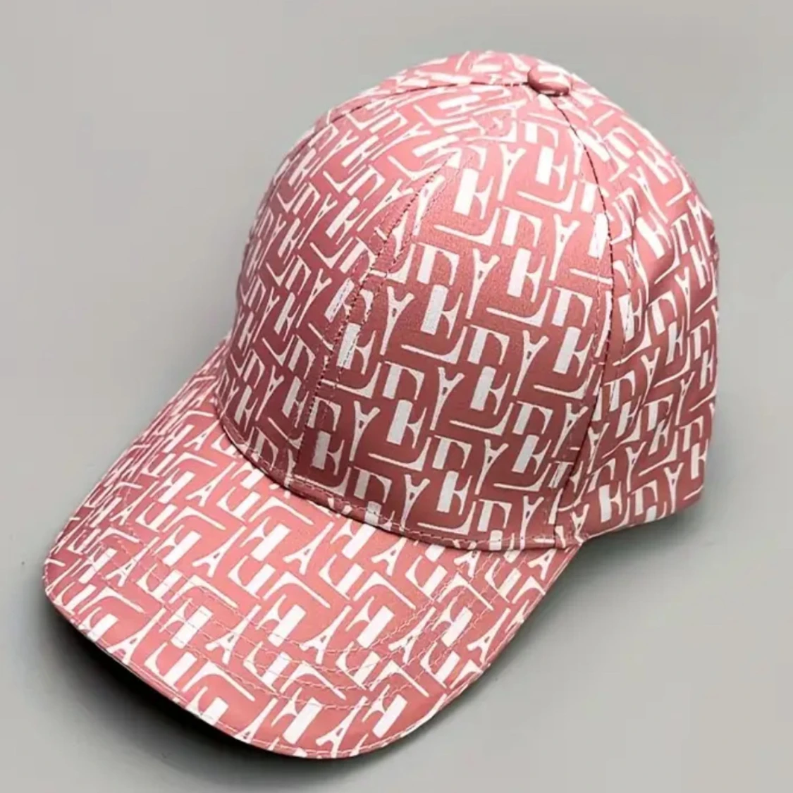 Rosa keps med vit logotypmönster