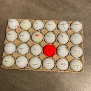 Titlest bollar, blandning  - Bilderna visar en samling golfbollar, bland annat från Titleist, inklusive en röd boll och en med Pink Panther. Mer än hälften av bollarna är prov1 och prov1x, resten av bollarna är avx, next tour och truffel