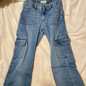 Jeans med fickor - Jeans i mjukt material från Lindex. Två fickor på sidan av låren där en är lite vikt. Barnstorlek 158.