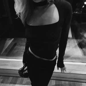 Svart långärmad topp med cut out - Trendig svart långärmad topp med unik cut out-detalj över bröstet och hög hals. Sitter tight och har en stilren, modern look som passar perfekt till jeans eller kjol. Materialet är ribbat och stretchigt. Toppen är från Zara 🩷