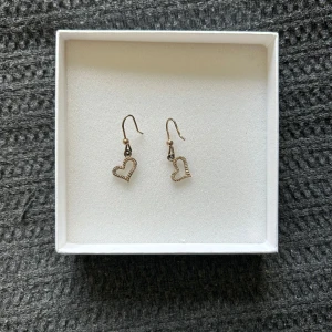  örhängen med hjärtan - Snygga örhängen med hängande hjärtan. Hjärtana har en detaljerad kant.