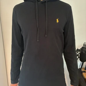 Svart hoodie från Ralph Lauren - En tunn Polo Ralph Lauren hoodie.            Köpt i butik.                                                   Skriv vid minsta lilla fundering