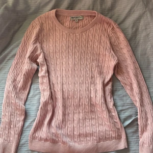 Rosa stickad tröja - Säljer denna supersöta rosa kabelstickade tröjan ifrån Basic You i st S. Den är i jättefint skick då den aldrig är använd och färgen är en väldigt mjuk nyans av rosa vilket gör den perfekt till alla årstider💓Perfekt att styla med jeans eller kjol, bara att skriva om nån fråga