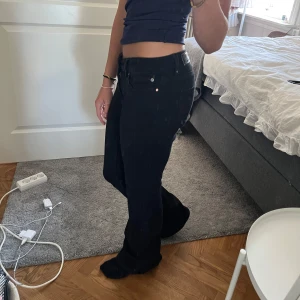 Svarta bootcut jeans från Vero Moda - Säljer ett par svarta bootcut jeans från Vero Moda. De har klassisk femficksdesign, låg midja och är tillverkade i stretchigt jeanstyg för en bekväm passform. Snygga att styla med crop top eller hoodie.