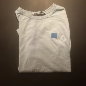 Ljusblå t-shirt från Acne Studios - Säljer en stilren ljusblå t-shirt från Acne Studios med klassisk passform och diskret logotyp-patch på bröstet. 