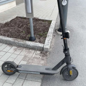 Svart elsparkcykel - Säljer en svart elsparkcykel med robust ram och bred fotplatta. Utrustad med handtag i gummi, ringklocka och reflexer på hjulen. Passar perfekt för smidig transport i stan. Laddningsport och stöd finns på sidan.