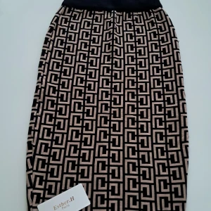 Beige och svart mönstrad kjol från Esther.H Paris - Säljer en snygg beige och svart kjol från Esther.H Paris med grafiskt mönster. Kjolen har resår i midjan och är tillverkad i en mjuk bomullsblandning. Perfekt för dig som gillar statement-plagg med unik design.