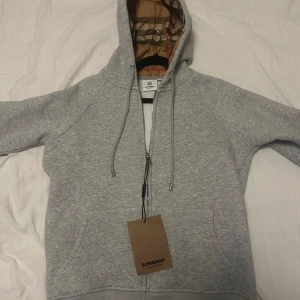 Grå hoodie från Burberry med mönstrad huva - Säljer grå burberry zip up hoodie