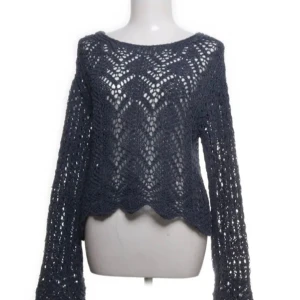 Blå stickad tröja med hålmönster från Zara - Säljer en blå stickad tröja med snyggt hålmönster och vågig nederkant. Tröjan har långa ärmar och en lös passform, perfekt för lager på lager