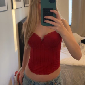 Korsett topp - Röd korsett topp från Gina Benotti. Jättefin verkligen och passar perfekt till fest eller andra event. Storlek 80B. Finns liten defekt (se bild 4) men inget som alls syns när man har på sig den💓 kontakta vid frågor🥰