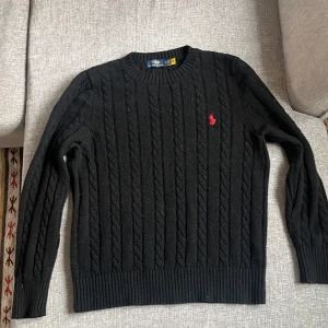 Svart kabelstickad tröja från Polo Ralph Lauren - Nu säljer jag min kabeltröja för att den börjar bli för liten för mig den är använd knappt . Perfekt för en stilren look.