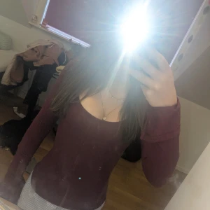 Vinröd långärmad topp med djup ringning - Säljer en vinröd långärmad topp med djup, rund ringning. Toppens material är stretchigt och sitter tight mot kroppen. Perfekt för dig som gillar en enkel men snygg stil. Inga synliga detaljer eller mönster.❤️❤️