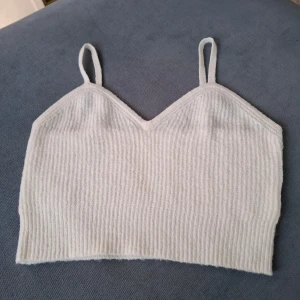 Stickad topp  - Vit stickad kort topp med smala axelband! Lappen bortklippt, stl S. Banden är kapade och ditsydda igen.