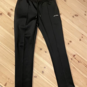 Svarta mjukisbyxor från Les Deux - Säljer ett par svarta mjukisbyxor från Les Deux med dragsko i midjan och broderad logga på ena benet. Skit snygga för en mer relaxed look men ändå stiligt. Dom är helt nyskick men pris kan diskuteras.