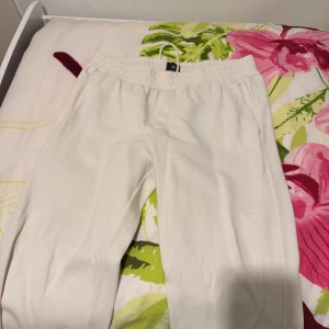 Beige mjukisbyxor - Säljer ett par beige mjukisbyxor med resår och dragsko i midjan. Byxorna har en avslappnad passform och är perfekta för en chill dag hemma eller till vardags. Gjorda i mjukt bomullsmaterial för extra komfort. Sommarkänsla också