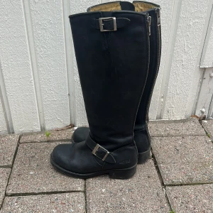 Johnny Bulls - Klassiska svarta höga läderboots från Johnny Bulls. Smått slitage (sista bilden). Annars mycket bra skick.                                                             Storlek: 37 (som en 38a)