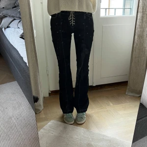 Mörkblåa bootcut jeans med snörning från Weekday - Säljer ett par mörkblåa bootcut jeans från Weekday med snygg snörning framtill i midjan. Storlek 26, eller 34. Sitter snyggt och är i fint skick. Jag är 169 cm lång, och på bilderna är mitt innerbensmått ca 82,5 cm och midjemått (platt mätt på mig) ca 31 cm.