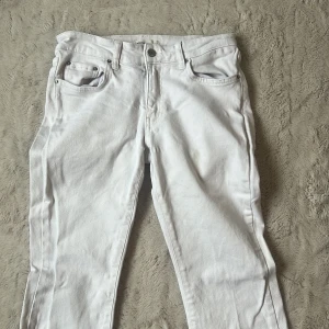 low waist vita jeans - Säljer ett par vita jeansbyxor med klassisk femficksdesign och bootcut ben. Köpta på ginatricot för 599kr. Säljer pga av att de inte kommer till användning 💞