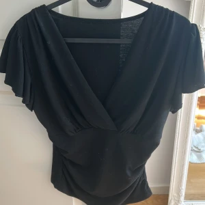 Blus - Säljer en snygg svart blus med volanger💞