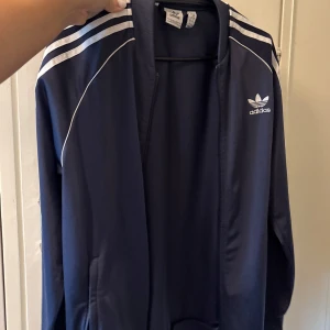Marinblå adidas med vita ränder - Marinblå adidas med vita ränder , storleken står på tröjan, förstår inte va det stod 