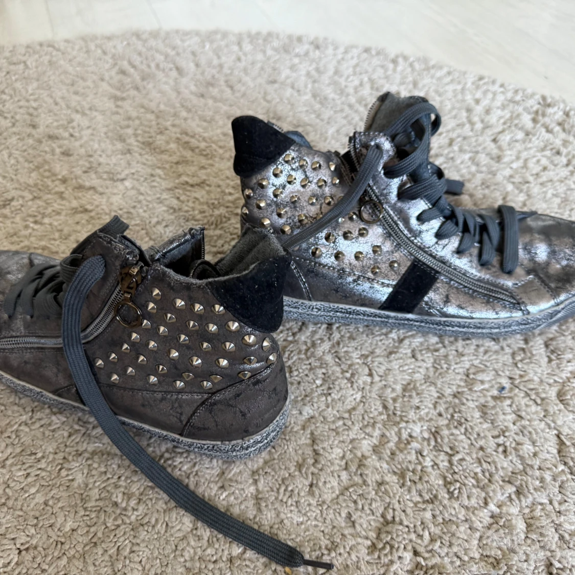 Grå sneakers med nitar och metallicdetaljer