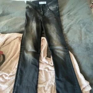 Svarta bootcut jeans från Bershka - Mid/low bootcut jeans från Bershka, med snygg vit ”fade” på bena. Bara använt några gånger, säljer på grund av att de blivit för små. Storlek 38