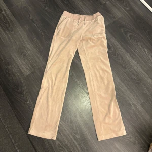 Beiga mjukisbyxor från Juicy Couture - Hej!🩷Säljer ett par beiga mjukisbyxor från Juicy Couture med raka ben och hög midja. Byxorna har stora fickor fram och bakfickor med knapp. Supermjuka och jätte sköna!🥰Storleken är som förväntat. I nästan nytt skick och felfria! Pris går att diskutera!🫶🏽 